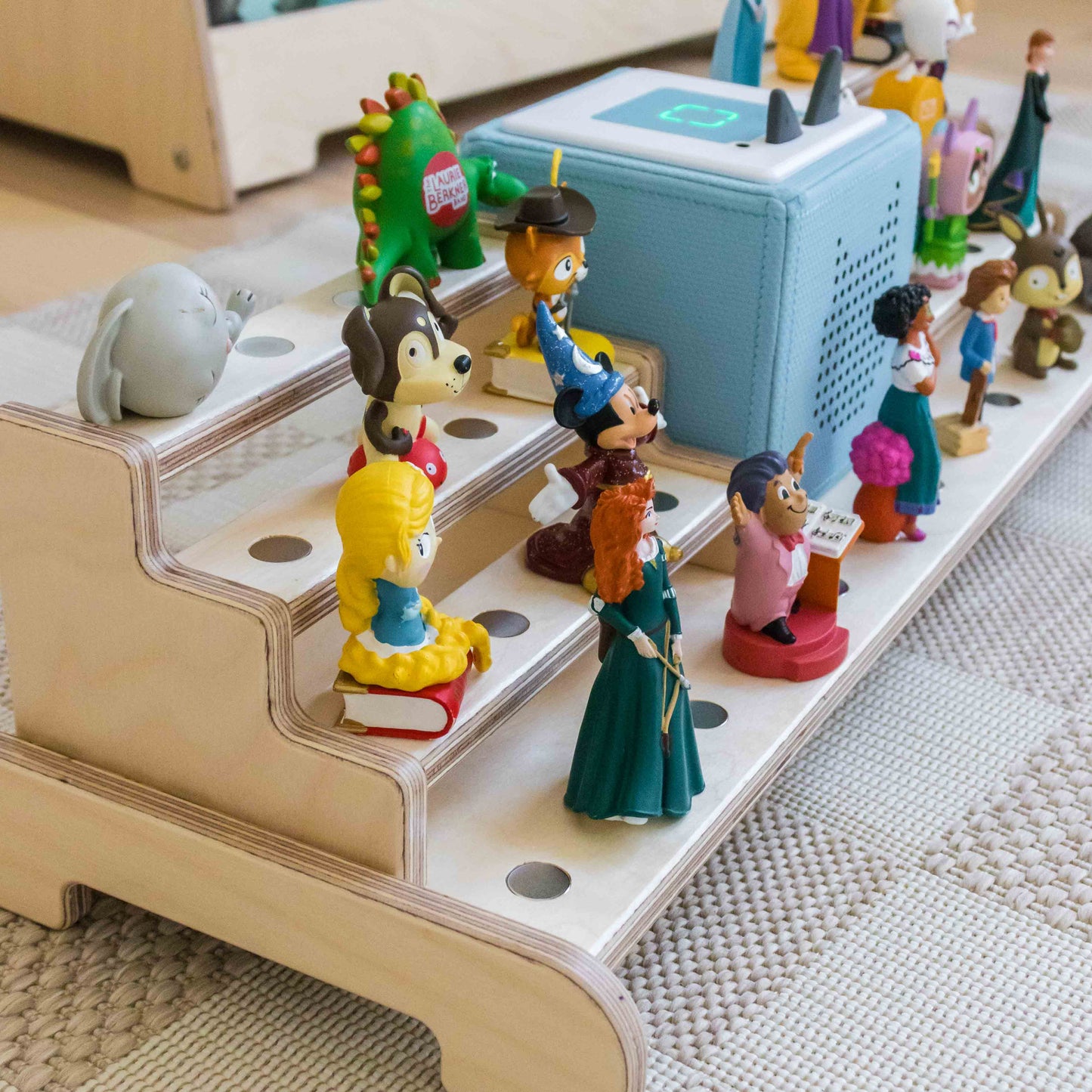 Close up of wooden tonie shelf holding a blue toniebox and tonie characters.