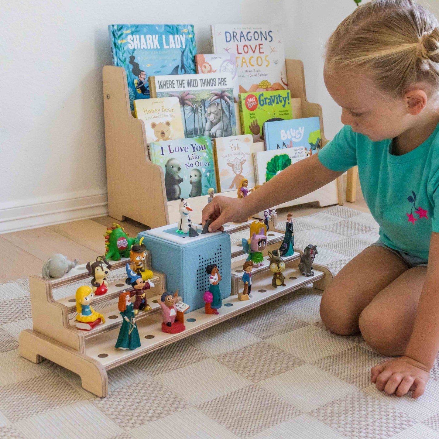 Child playing with a wooden toy set on a checkered floor with books in the background.
