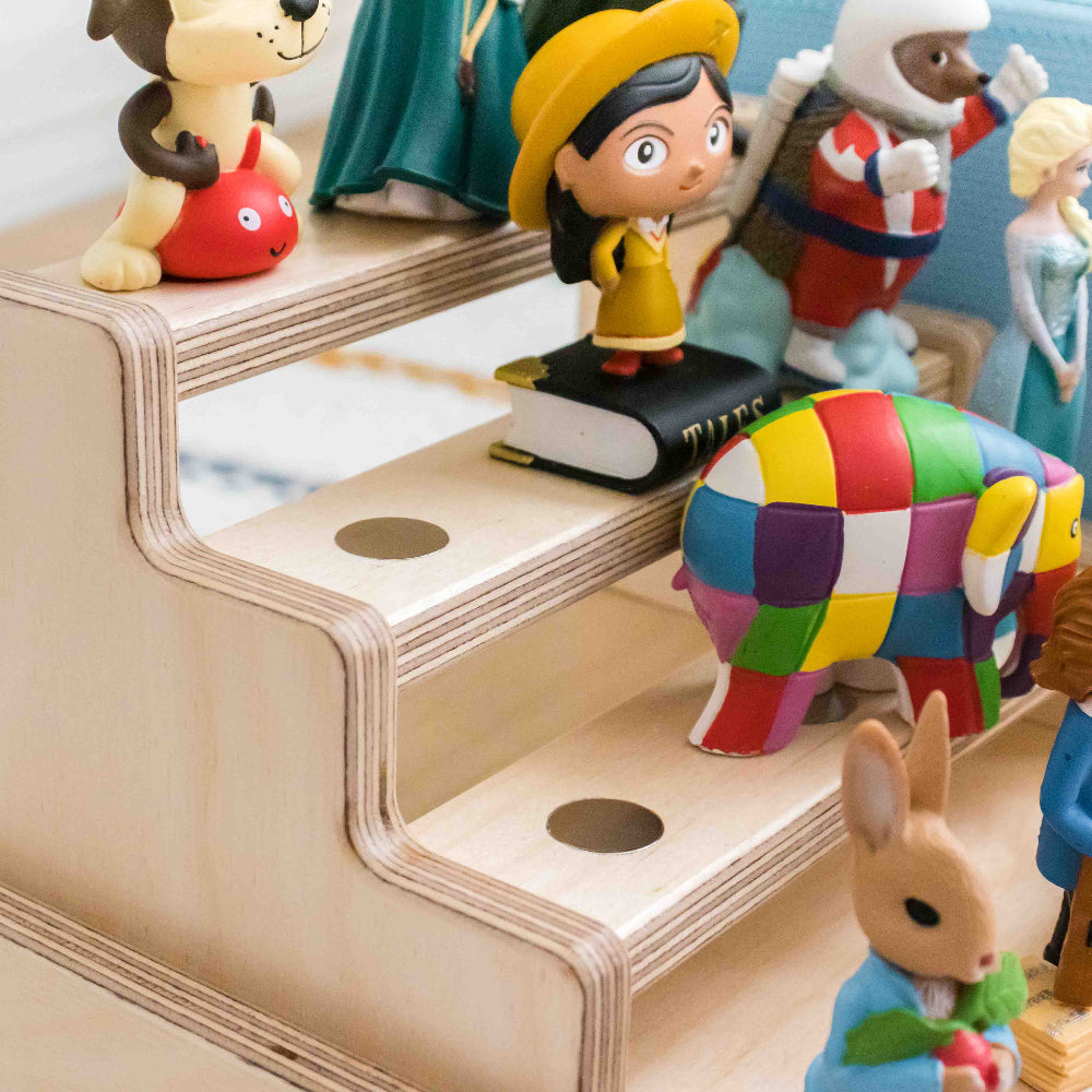 Close up of a tonie display made from wood showing its built in inserted metal dots designed to help keep the magnetic tonies in place.