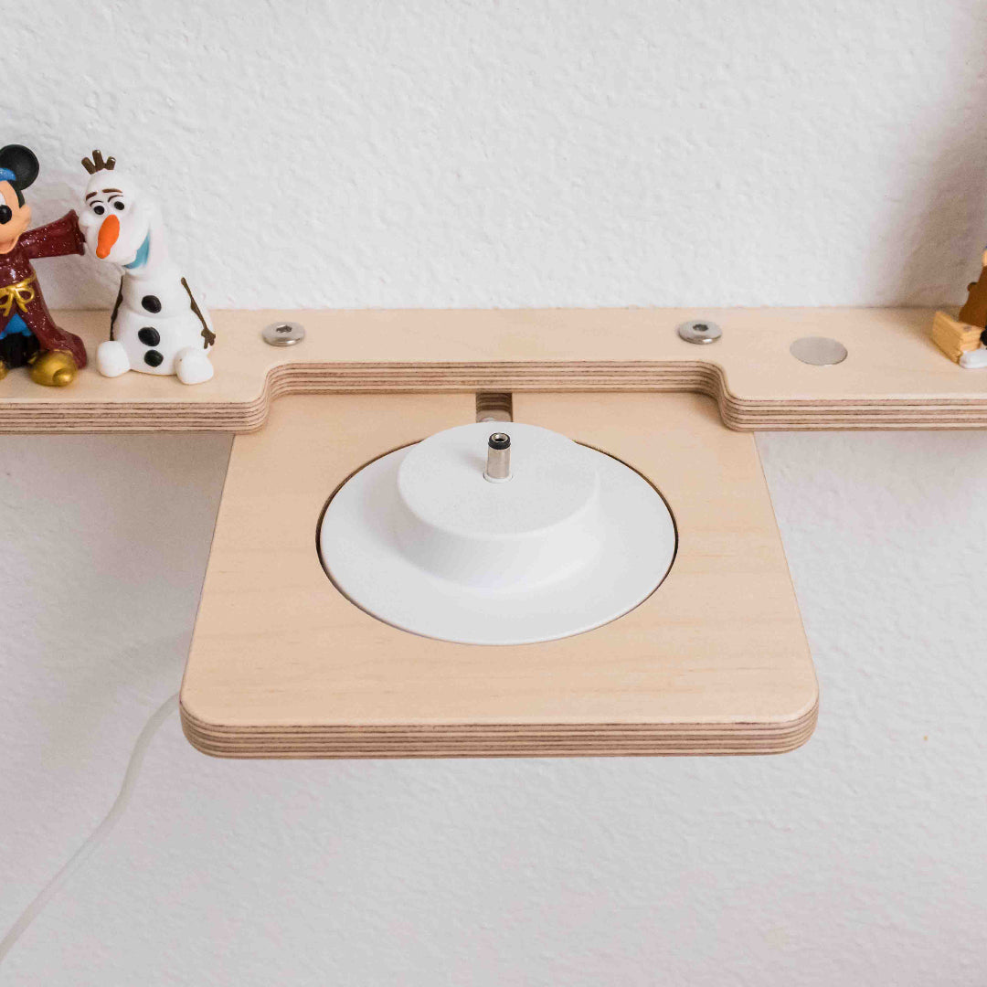 Close up of a tonie shelf showing its built in design to specifically hold the charging port for a toniebox.