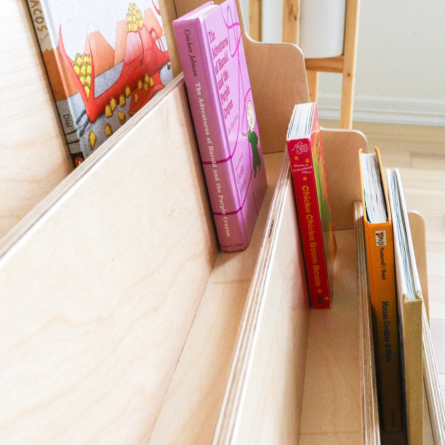wooden bookshelf with tilted shelves to keep children books in place.