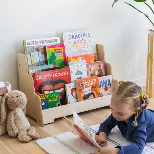 Halle reading on the floor next to her front-facing bookshelf