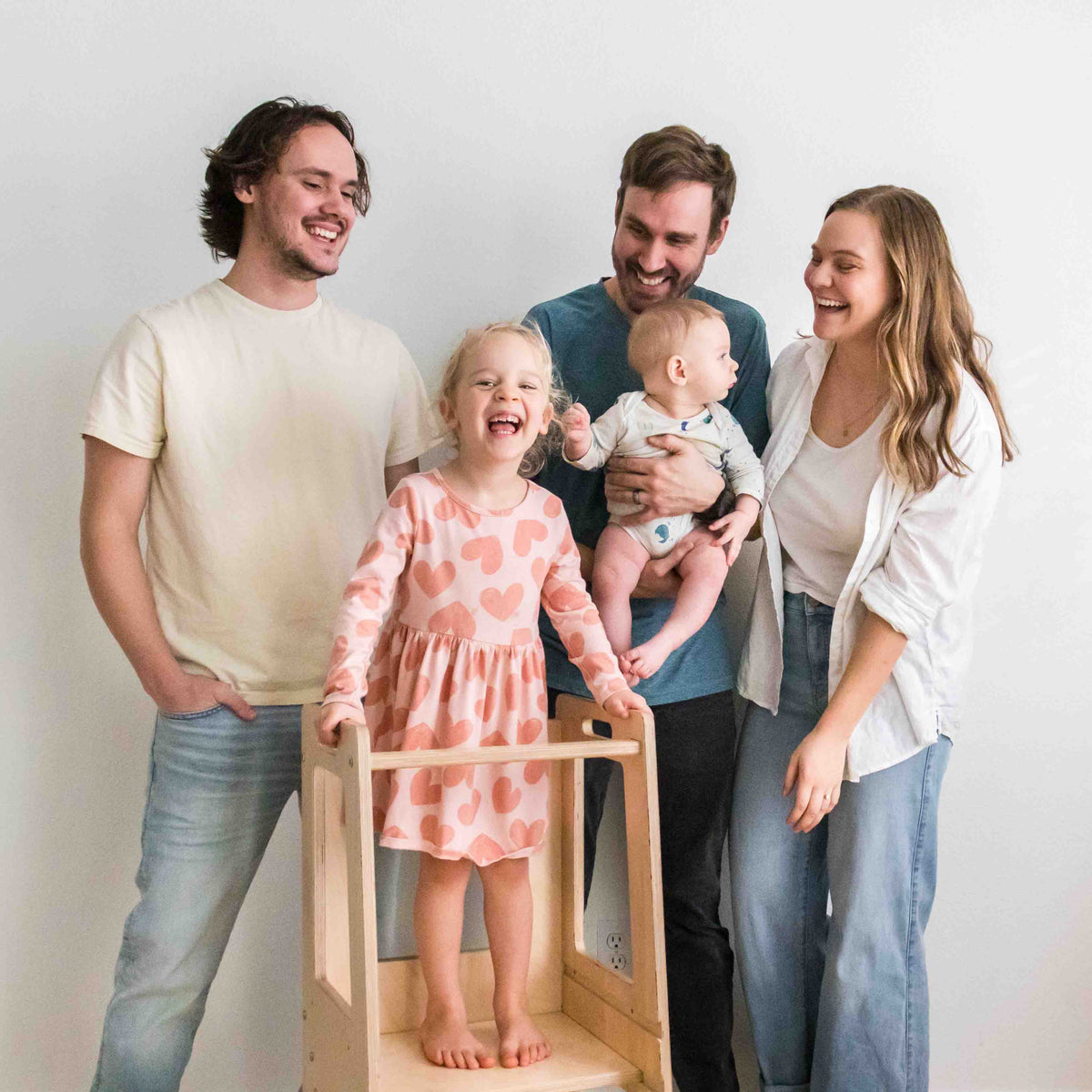 The Halle's Corner family together at home, with Halle standing in the learning tower that started it all