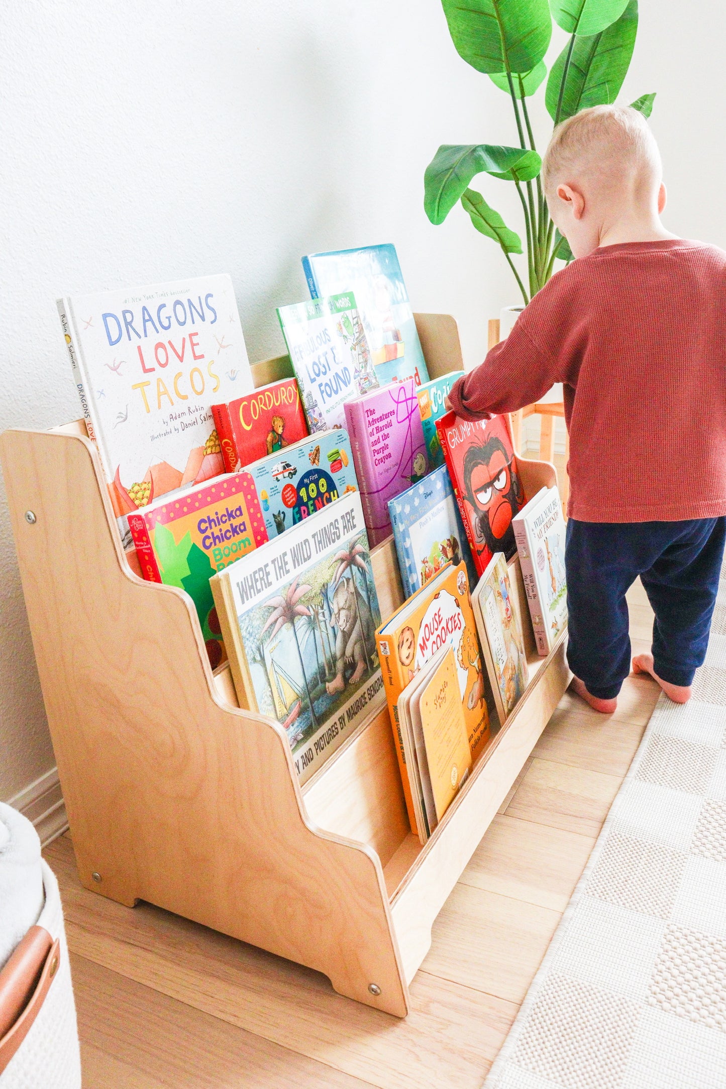 Side view of a kids bookshelf showing the birch wood and tilted shelves. 