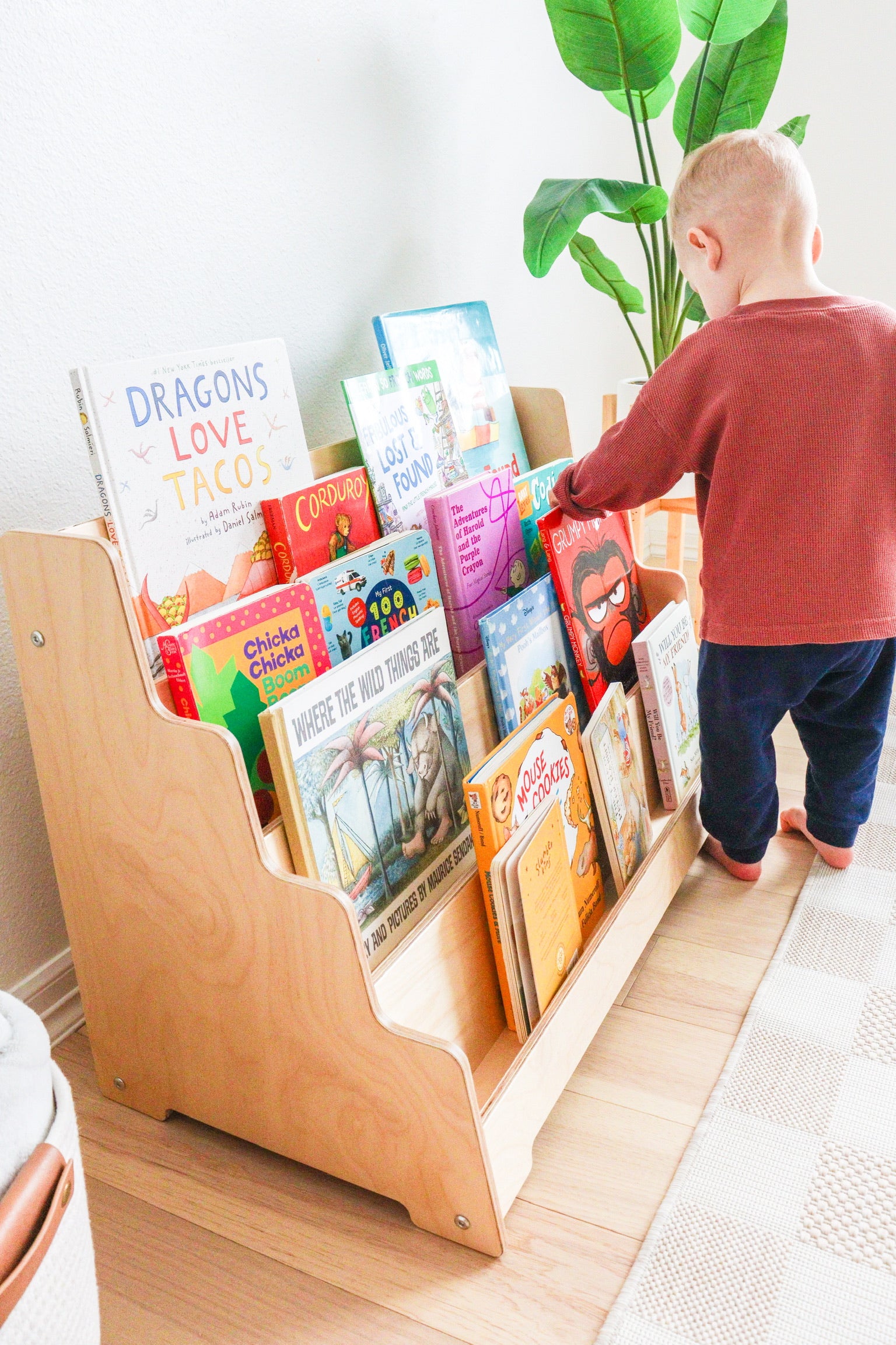 Side view of a kids bookshelf showing the birch wood and tilted shelves. 