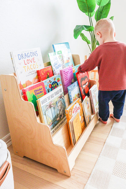 Side view of a kids bookshelf showing the birch wood and tilted shelves. 
