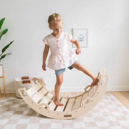 A child standing on a beige wooden climbing arch indoors.