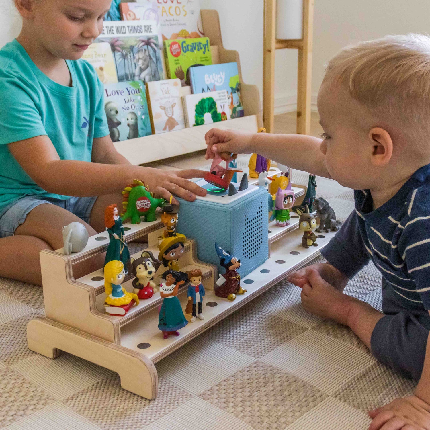 Children playing with Tonies on a large wooden tonie storage display shelf. 