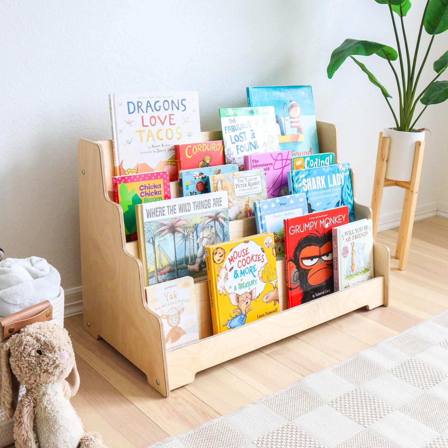 Children's bookshelf with front facing shelves with various books in a room setting
