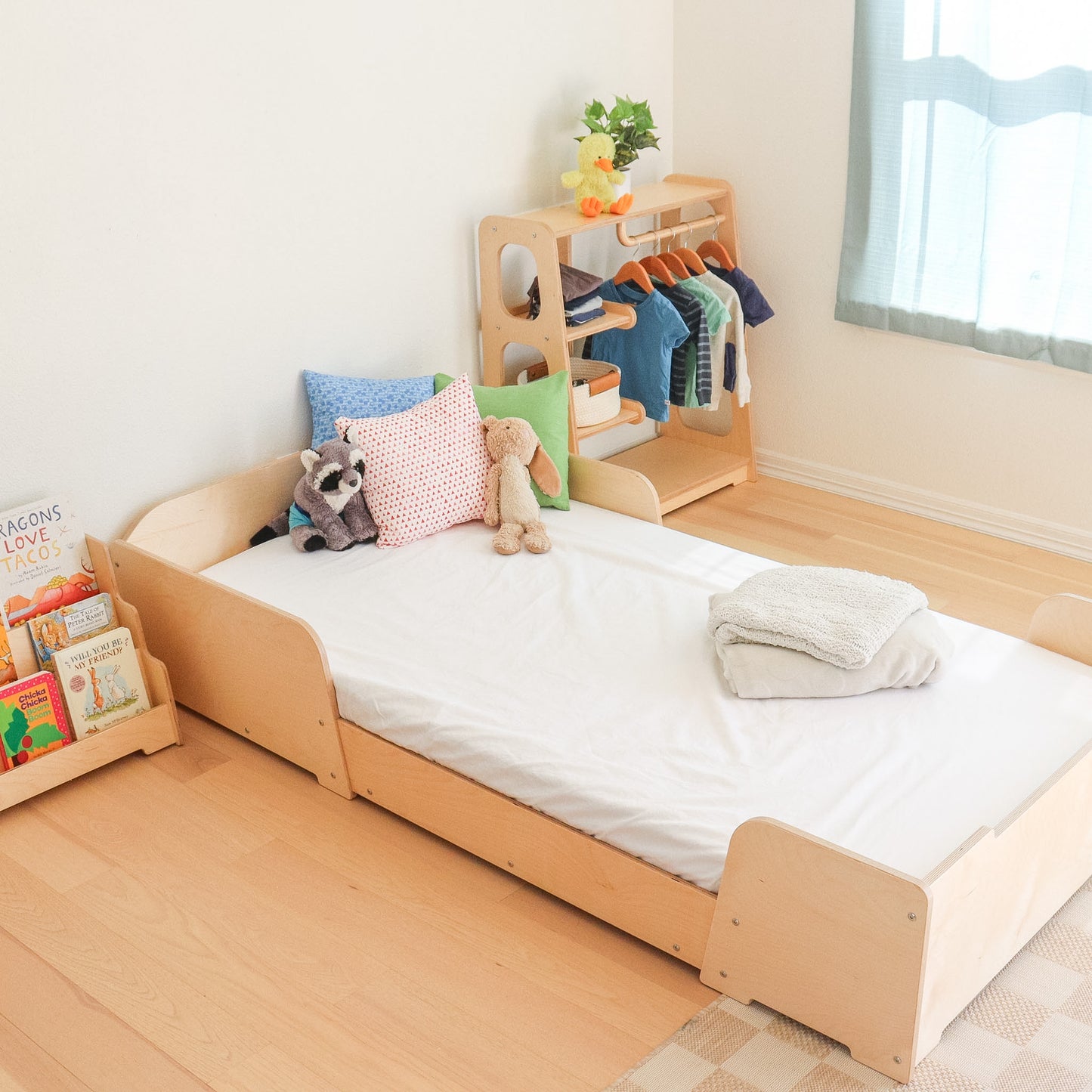 Children's room with a wooden bed, books, and a small clothes rack.