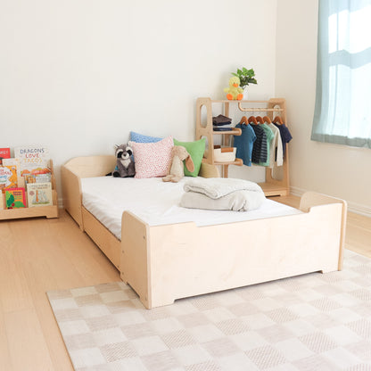 Montessori inspired room setup with a floor bed, toddler wardrobe, and forward facing bookshelf. 