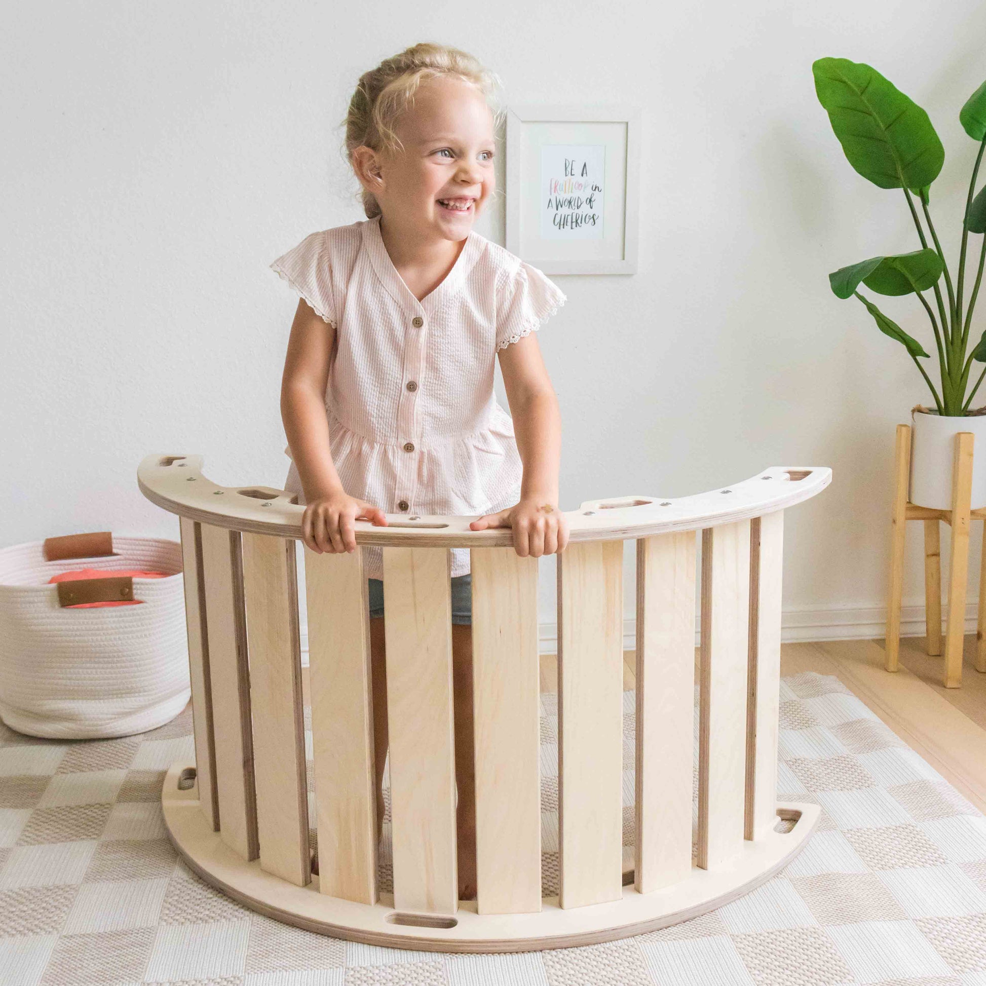 young girl using a rocking arch for a play setup.