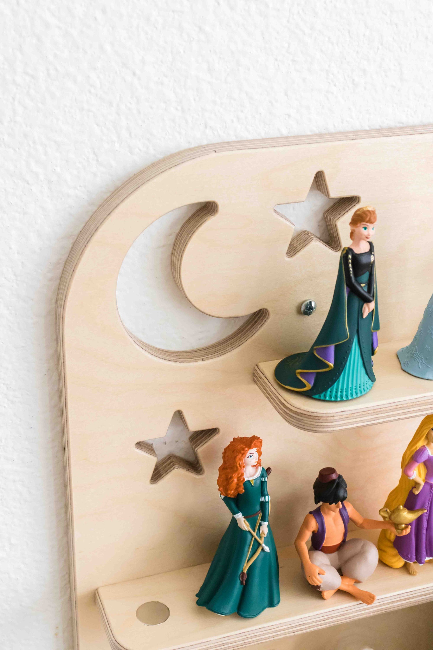 A wooden wall shelf holding a variety of tonie figures 