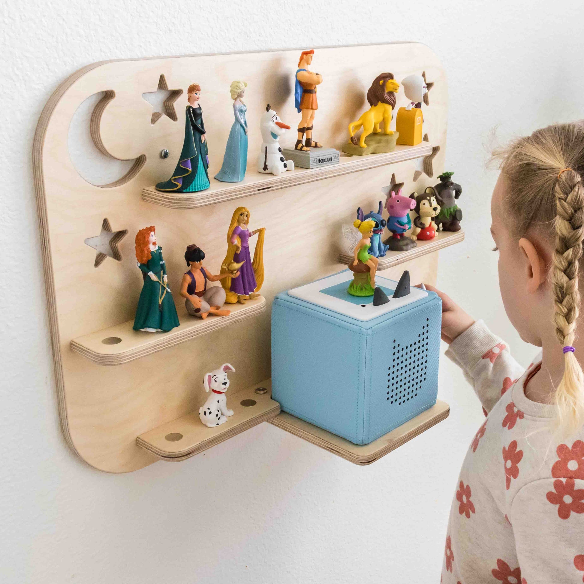Kind playing with a blue tonuebox on a wooden shelf