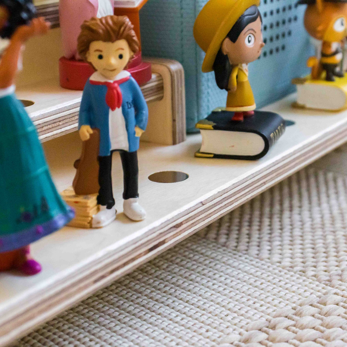 Tonie figures on a wooden surface with a textured rug background